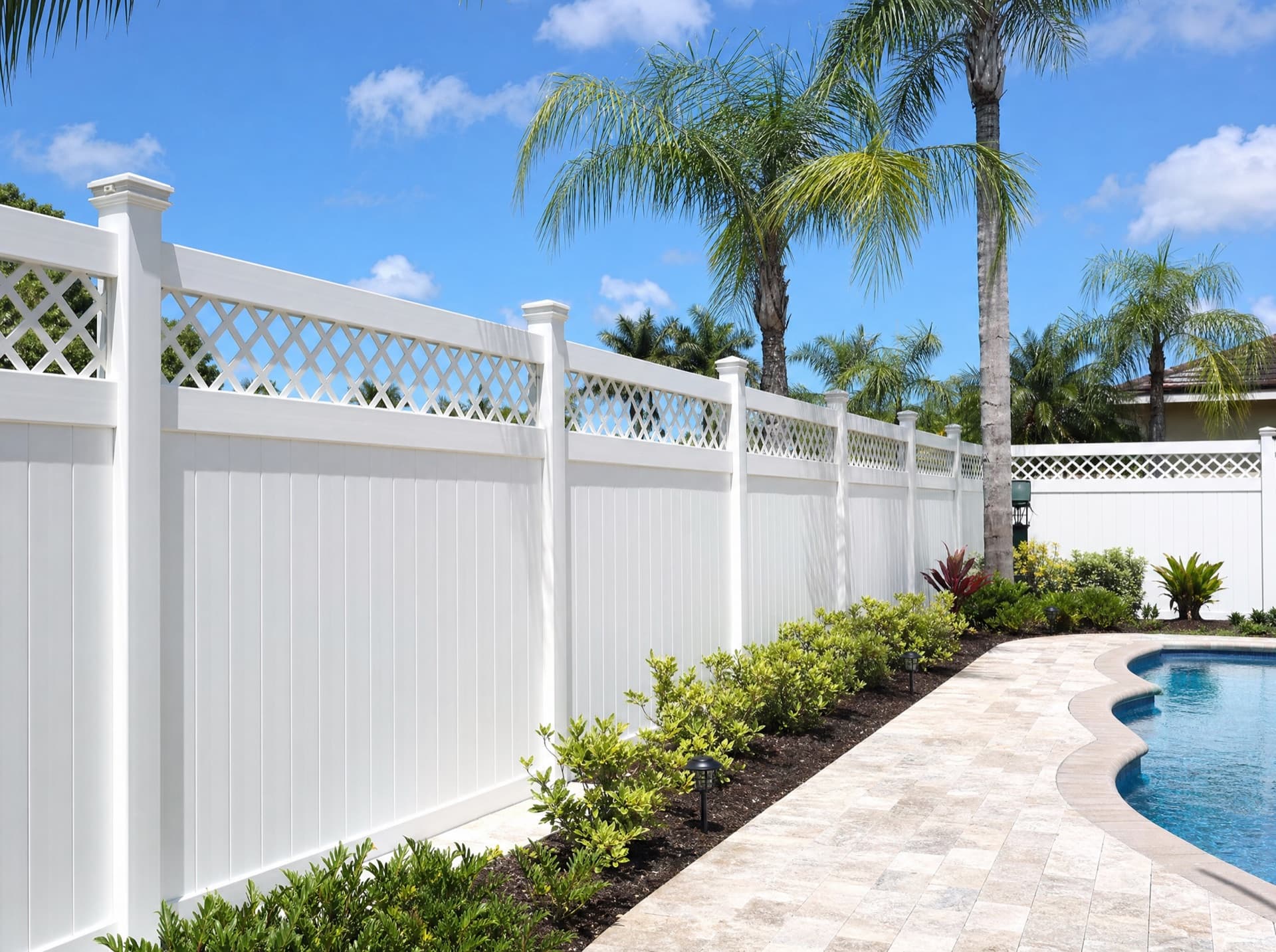 White vinyl privacy fence with lattice top beside a Florida pool deck